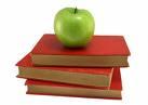 stack of red books with green apple on top
